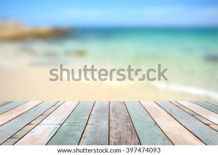Wood table top with blurred nature scene tropical beach and blue sky, holiday background concept - can be used for display or montage your products
