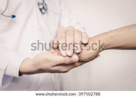 Two people holding hands for comfort. Doctor consoling relatives of patients.  Vintage tone. Royalty-Free Stock Photo #397502788