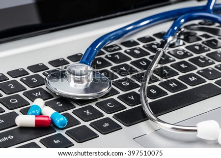 Medical Research, stethoscope and Capsule on laptop keyboard, doctor workplace