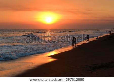 Memory of a sunset with the silhouette of people walking along the beach in Monterrico by the Pacific Ocean, Guatemala. 