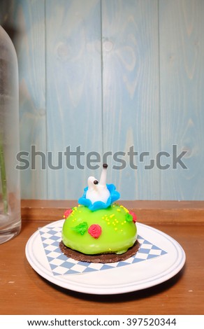 Alice Cake, Alice is falling into the Bush with her legs up in the sky. Green tea cake. Alice's Adventure in Wonderland is written by Lewis Carroll. Copy space