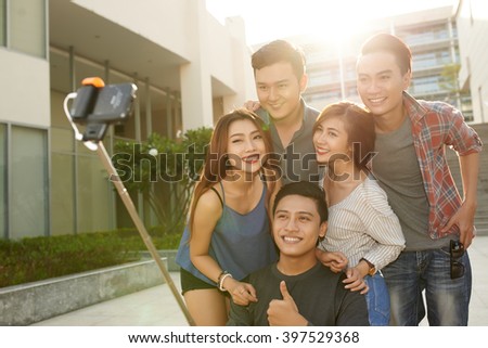 Smiling Vietnamese guys and girls taking selfie together