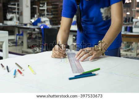 fashion designers, working in progress on tailor table in factory.