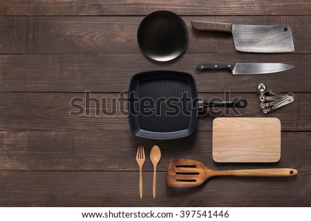 Various kitchenware utensils on the wooden background for cooking. Royalty-Free Stock Photo #397541446