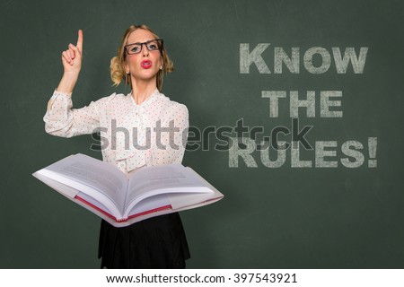 Teacher holds rule book know the rules message classroom lecture discipline motivational card Royalty-Free Stock Photo #397543921