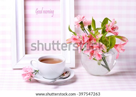 
Good morning. cup of tea, white frame and a vase of flowers on a beautiful background