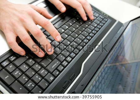 Close-up of male hand over black keyboard of laptop during typing