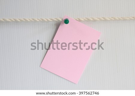 Paper note on the light brown wall with rope