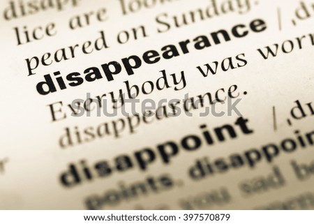 Close up of old English dictionary page with word disappearance