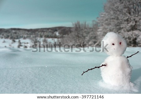 Snowman. Little snowman. New Year card. Winter mood. Lonely snowman on beautiful background. Snowman. Cute picture with a snowman