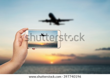 Hand of women with smart phone shooting photograph on blurred airplane and beach sunset in twilight, Plane, Phone, Hand