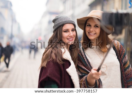 Trendy young women taking selfies in the city