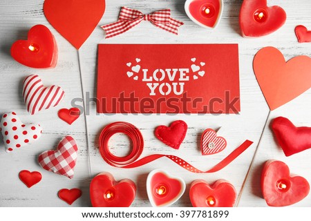 Valentine concept. Inscription I Love You with hearts and candles on wooden table background