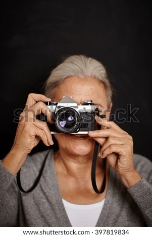 Mature woman taking photograph