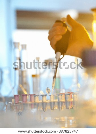 Scientist pipetting sample into eppendorf vial during experiment in laboratory
