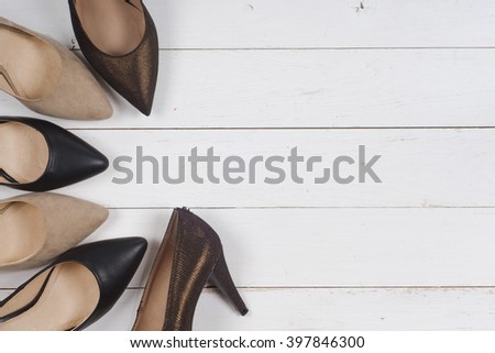 A picture of different shoes, Shot of several types of shoes, Several designs of  women shoes. Leather Shoe, Sport Shoe. Pile of various female shoes on wooden background