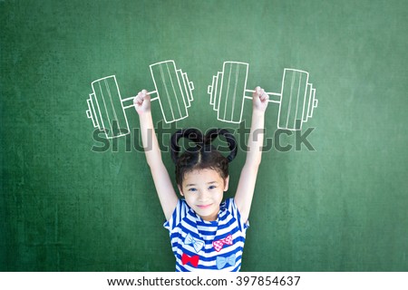 Empowering woman and girl gender rights concept for international day of girl child, and sports for development and peace with healthy strong kid with dumbbell exercise doodle on school chalkboard Royalty-Free Stock Photo #397854637