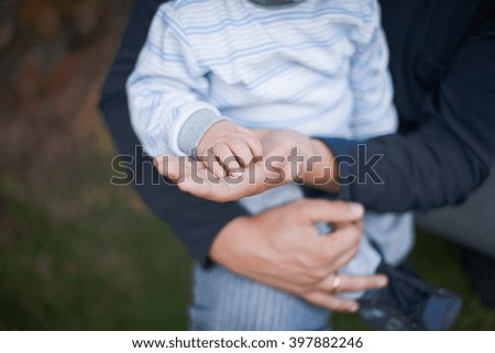 little boy holds dad's palm