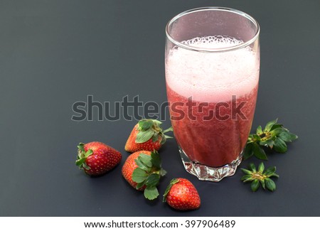 Strawberry juice with many strawberries on isolated black background