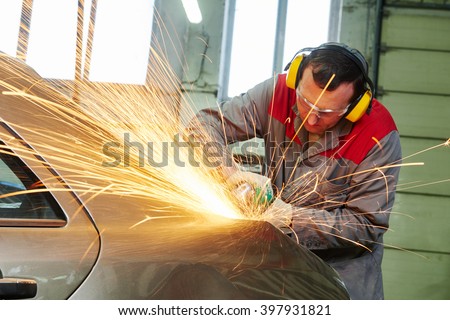 collision repairs service. mechanic grinding car body by grinder Royalty-Free Stock Photo #397931821