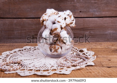 cotton flowers and pearls on a wooden background