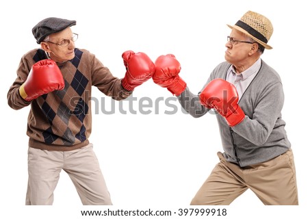 Studio shot of two competitive seniors fighting each other with boxing gloves isolated on white background Royalty-Free Stock Photo #397999918