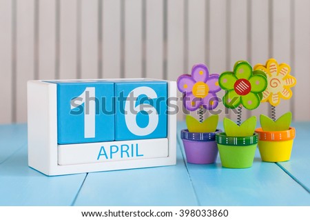 April 16th. Image of april 16 wooden color calendar on white background with flowers. Spring day, empty space for text
