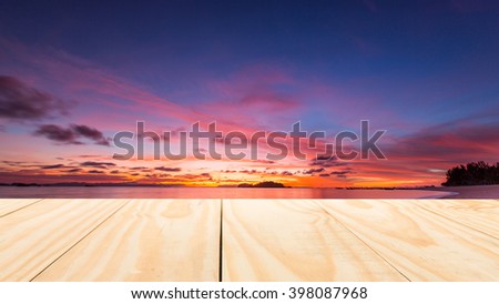 image of wood table top on sunrise over tropical sea of thailand background. can be used for display or montage your products