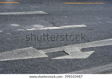 arrow sign on surface of street