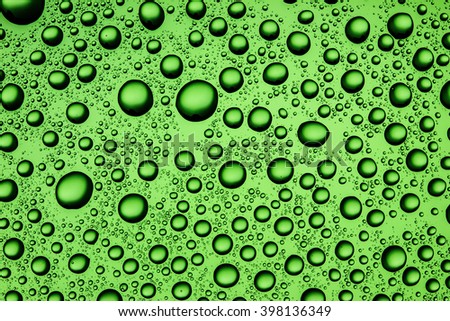 Water drops on green glass surface texture.