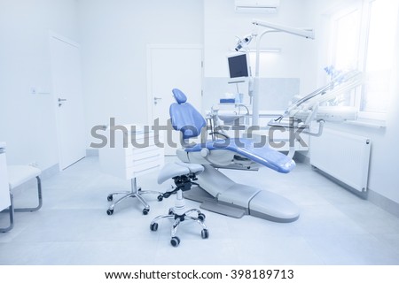 Modern dental practice. Dental chair and other accessories used by dentists in blue, medic light Royalty-Free Stock Photo #398189713