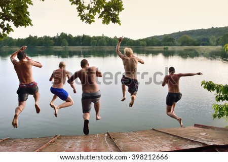 Happy young boys jumping togetherto the calm summer sea, adventure team photo on summer holiday or vacation, summer memories, original wallpaper full of happiness and energy Royalty-Free Stock Photo #398212666