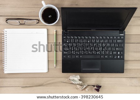 coffee with notebook,flower,pencil,eye glasses on wood background