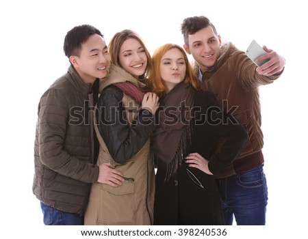 Young people taking selfie in their winter clothes isolated on white