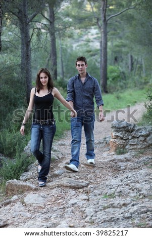 Beautiful young couple walking on a forest path