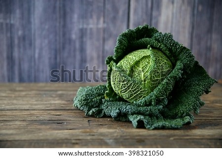 Raw savoy cabbage on wooden and grey background Royalty-Free Stock Photo #398321050