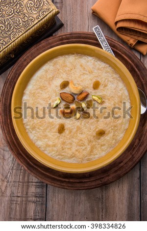 Seviyan / vermicelli kheer / khir, is a popular dessert consumed especially on  Eid or any other festival in india/asia. Served in a bowl dry fruits over colourful/wooden background. Selective focus