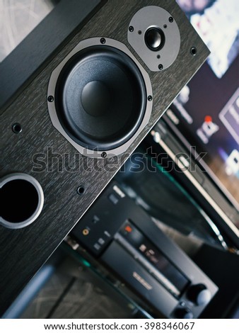 Home entertainment center. Close-up audio speaker. Shallow depth of field. Low angle verical tilt view.