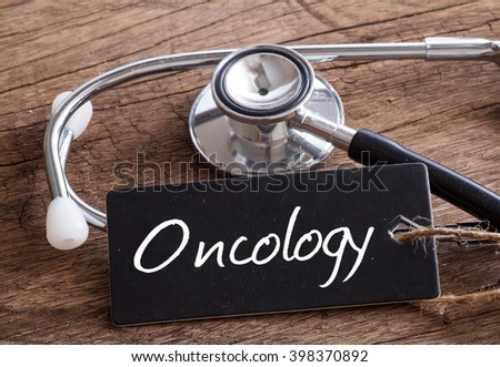 Stethoscope on wood with oncology word as medical concept Royalty-Free Stock Photo #398370892