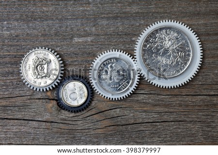 Gears with coins inside on old boards