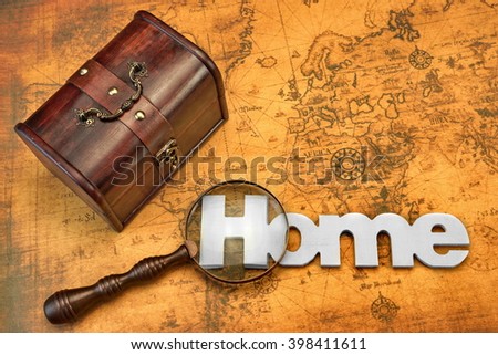 Home Search Or Emigration Concept. Bag Or Storage Box, Wooden Sign Home And Magnifier On the Old Map Background, Top View, Close Up