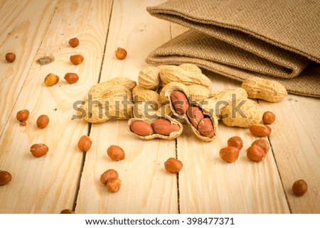 Peanuts on a wooden background .