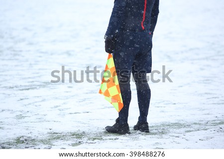 Assistant of referee with flag work at snow weather