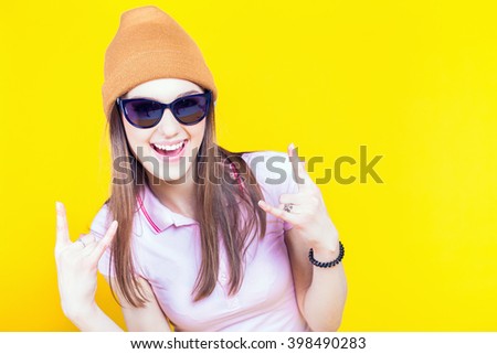 Funny teenage girl dressed in sunglasses and hat. Fashion student. Cool girl. Shopping. Color