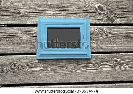 White wooden floor with teal picture frame and chalkboard