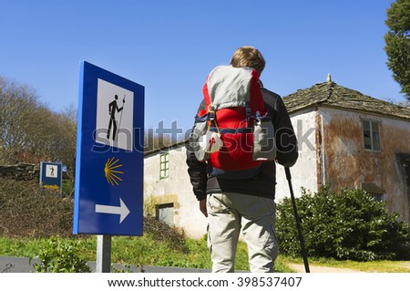 Camino de Santiago to Compostela with young pilgrim with backpack and scallop sympol  near Palas de Rei village in Galicia, Spain Royalty-Free Stock Photo #398537407