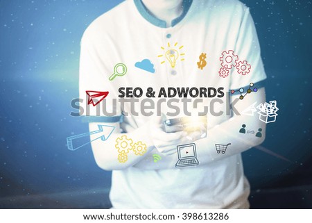 Young man holding a smart phone  with SEO AND ADWORDS  text ,business concept 