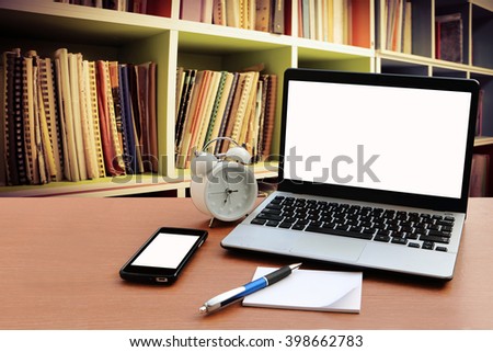 laptop and mobile phone on table with perspective bookshelf background