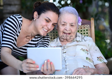 grandma and granddaughter taking a selfie with a tablet