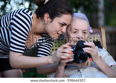 young girl shows pictures to grandma on photo camera